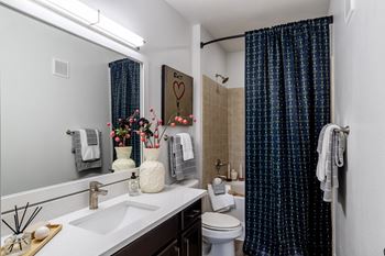 Bathroom with toilet and bathtub with curtain